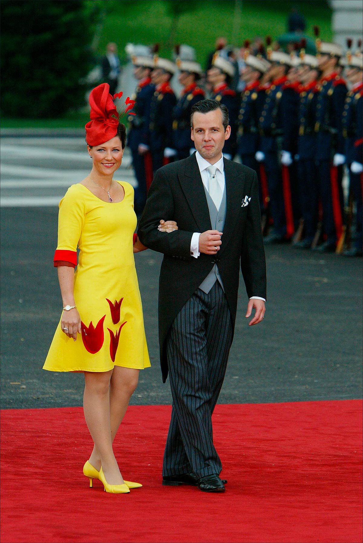 Marta Luisa de Noruega, junto a Ari Behn, llevó un original vestido en tonalidades amarillas y rojas. Lo completó con un tocado rojo y unos zapatos amarillos. 