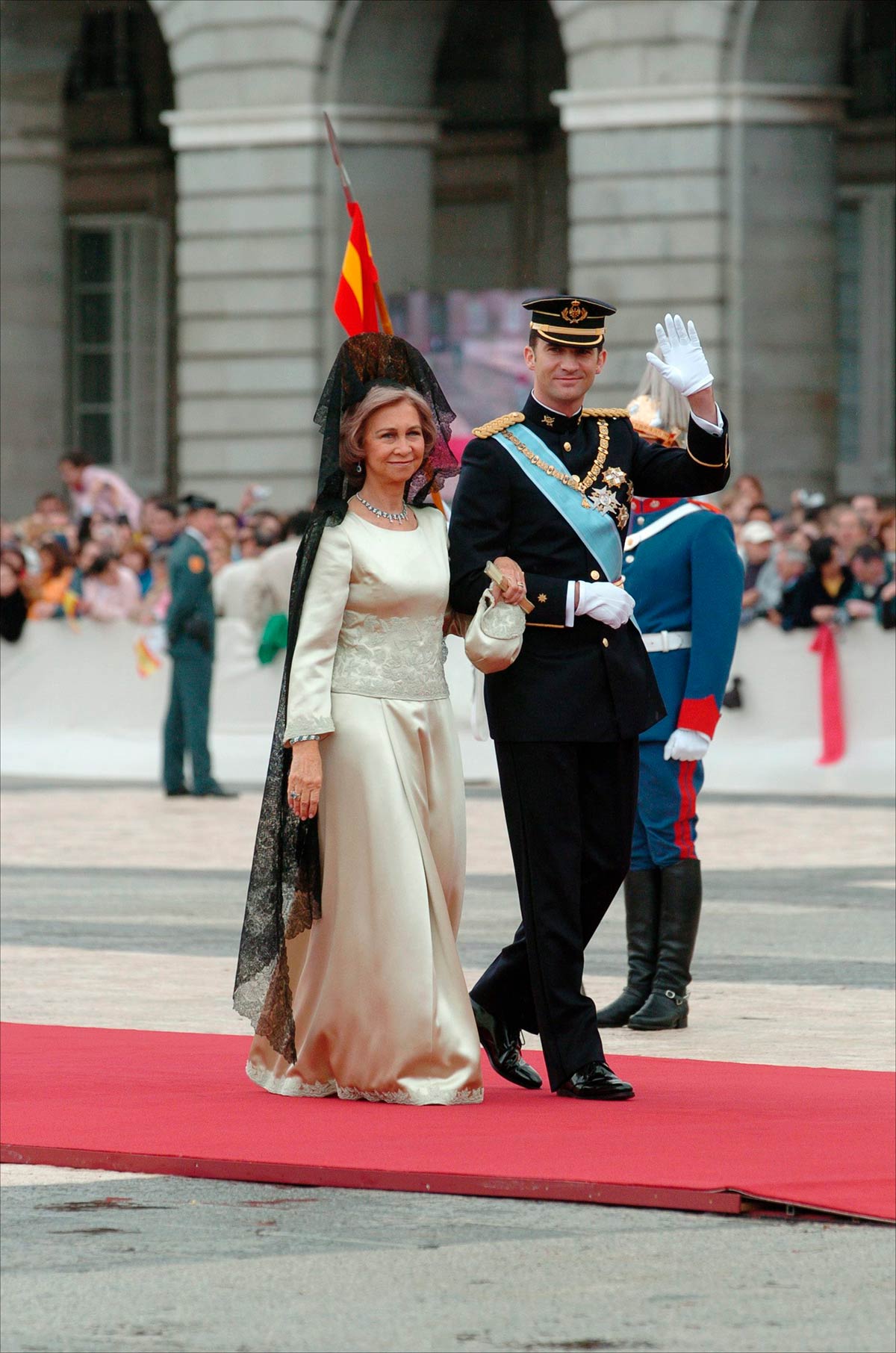 Doña Sofía, la madre del novio y madrina del enlace lució un vestido satinado, de manga larga, cuello redondo y con detalles bordados  firmado por Margarita Nuez. Lo combinó con un collar de perlas y esmeralda y tal y como manda el protocolo, llevó una mantilla negra. 