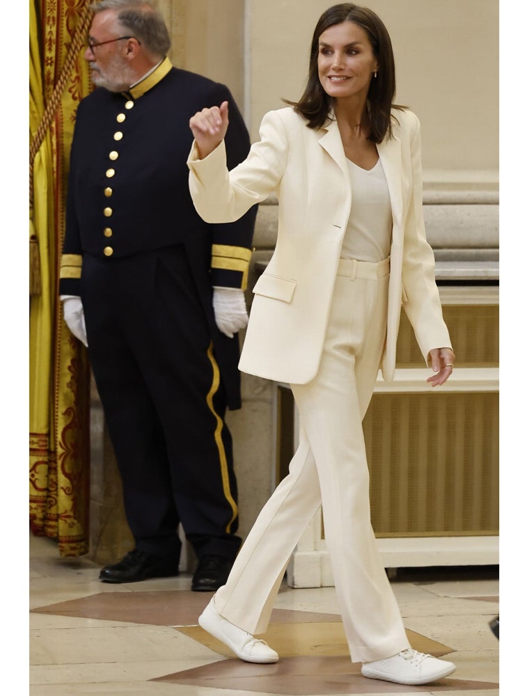 La Reina con traje blanco de la colección de Victoria Beckham para Mango, y zapatillas de Vivobarefoot.