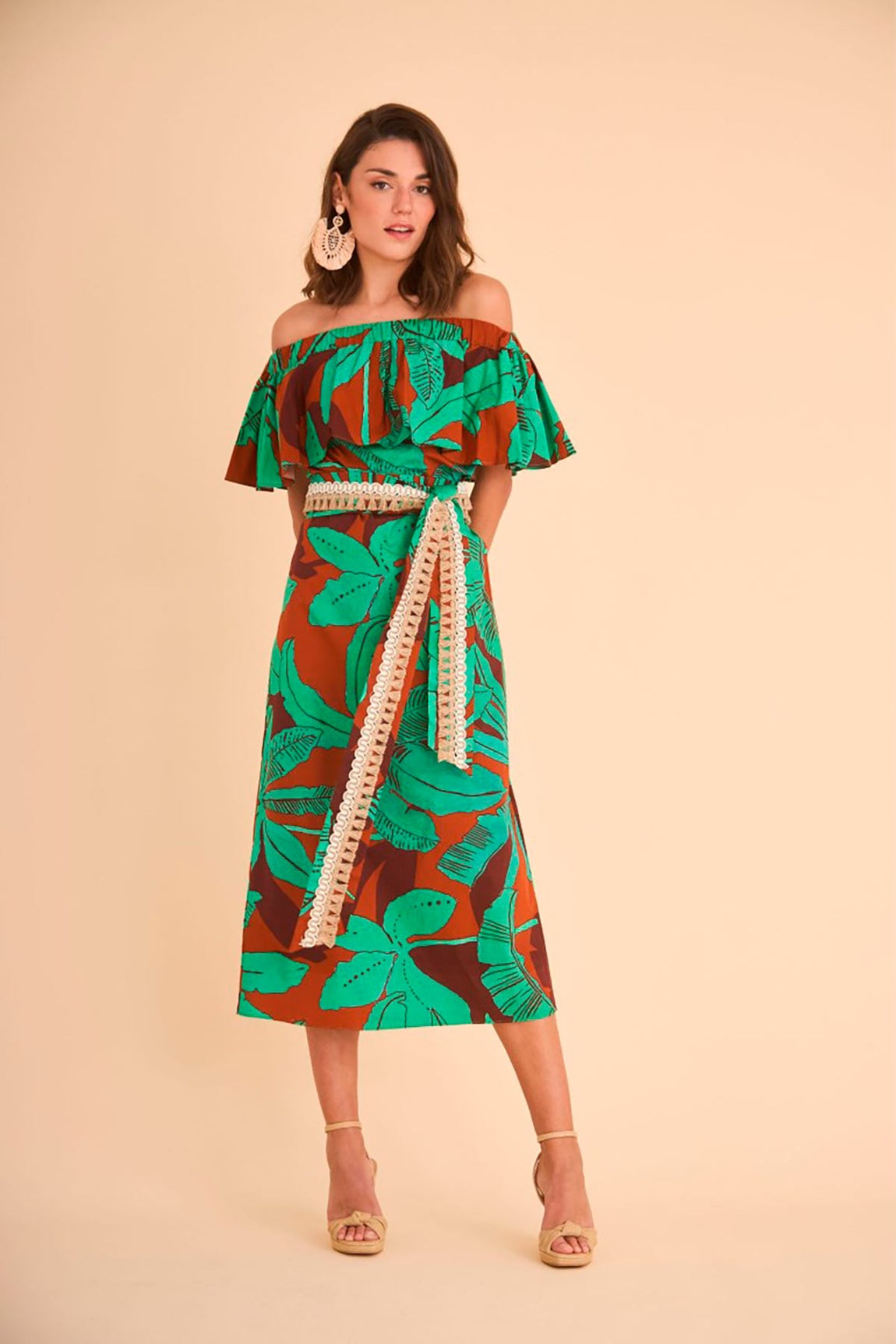 Vestido de corte midi con estampado tropical, escote palabra de honor con maxi volante y cinturón. Antes costaba 120 euros en Coosy. Ahora, 85 euros.