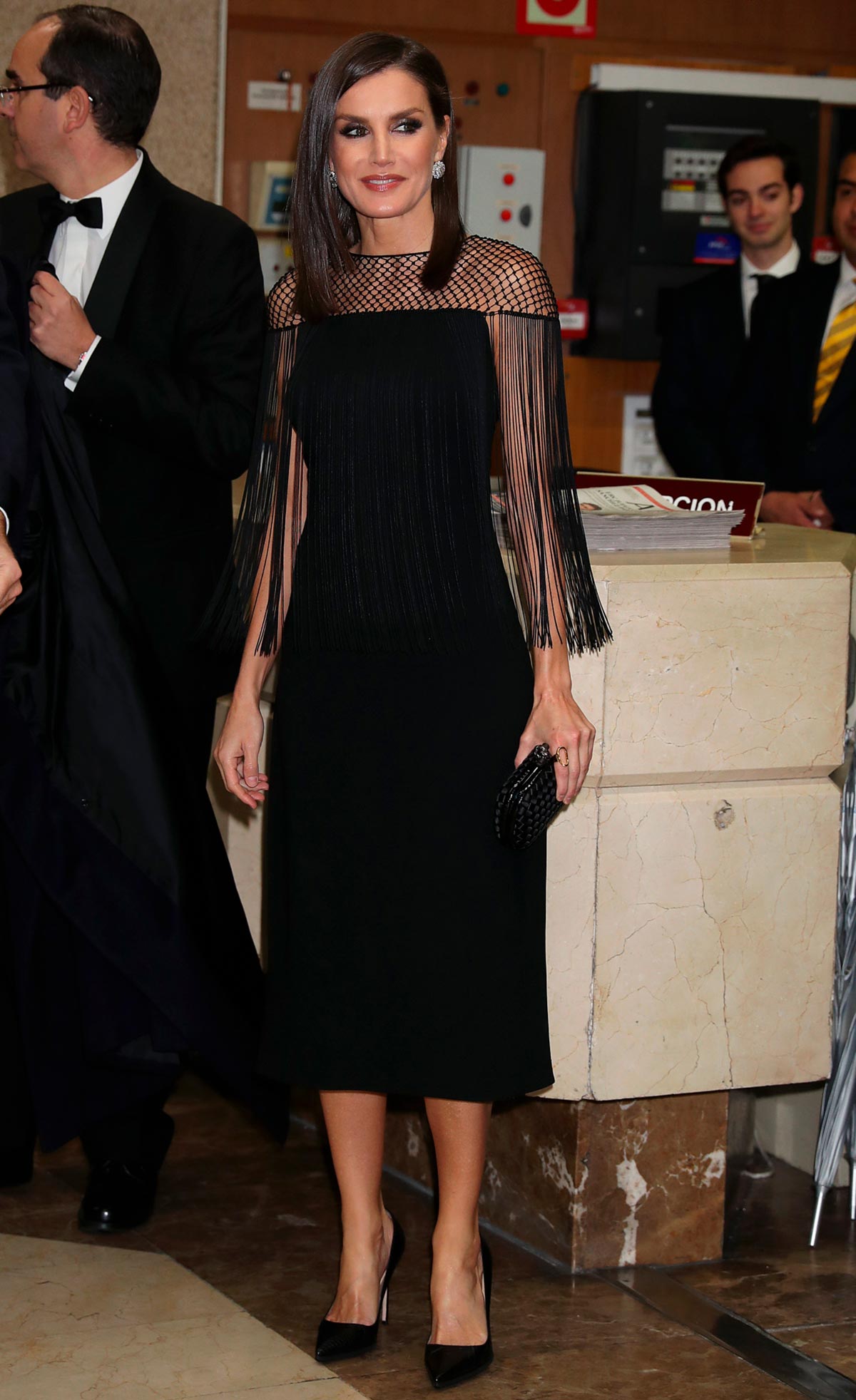 En 2019 llevó un vestido negro de corte midi que destacaba por su escote con rejilla y flecos. Firmado por Hugo Boss, lo combinó con tacones de Manolo Blanhik y un bolso de mano de Bottega Veneta, ambos en color negro. 