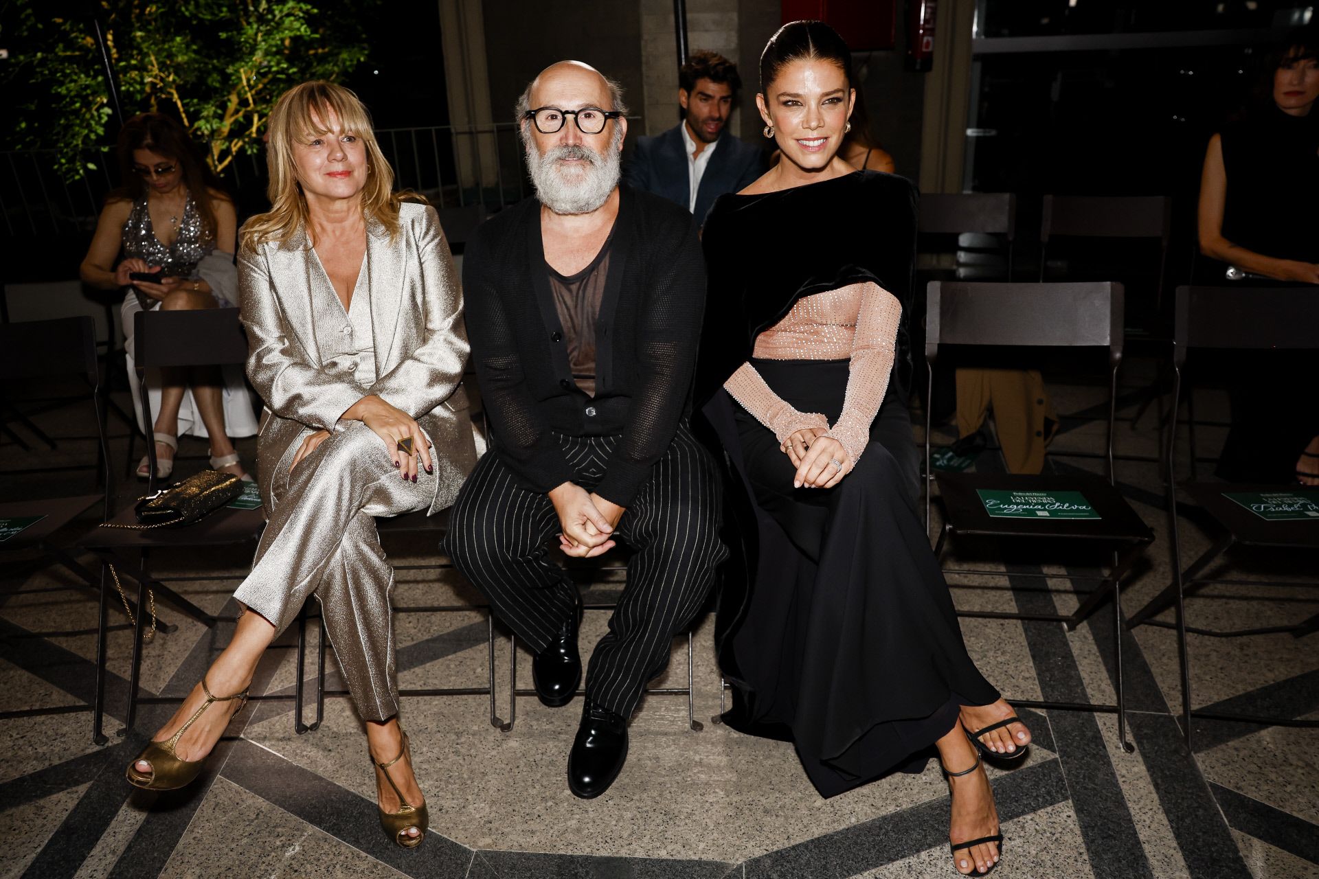 Los actores Emma Suárez, con traje metalizado, Javier Cámara, de negro, y Juana Acosta, con un elegante conjunto compuesto por falda negra larga y top nude, en el 'front row' del desfile de Pedro del Hierro. 