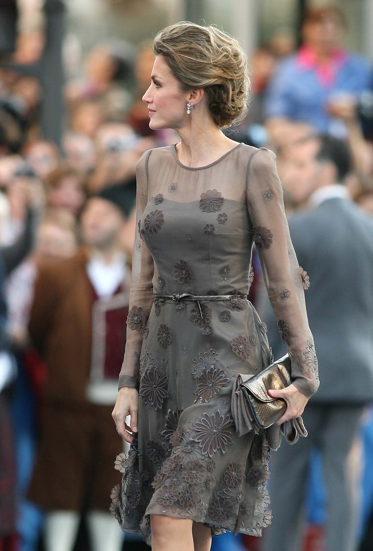 En 2011, la monarca apostó por un vestido gris con bordados florales en relieve. Añadió un bolso metalizado. 