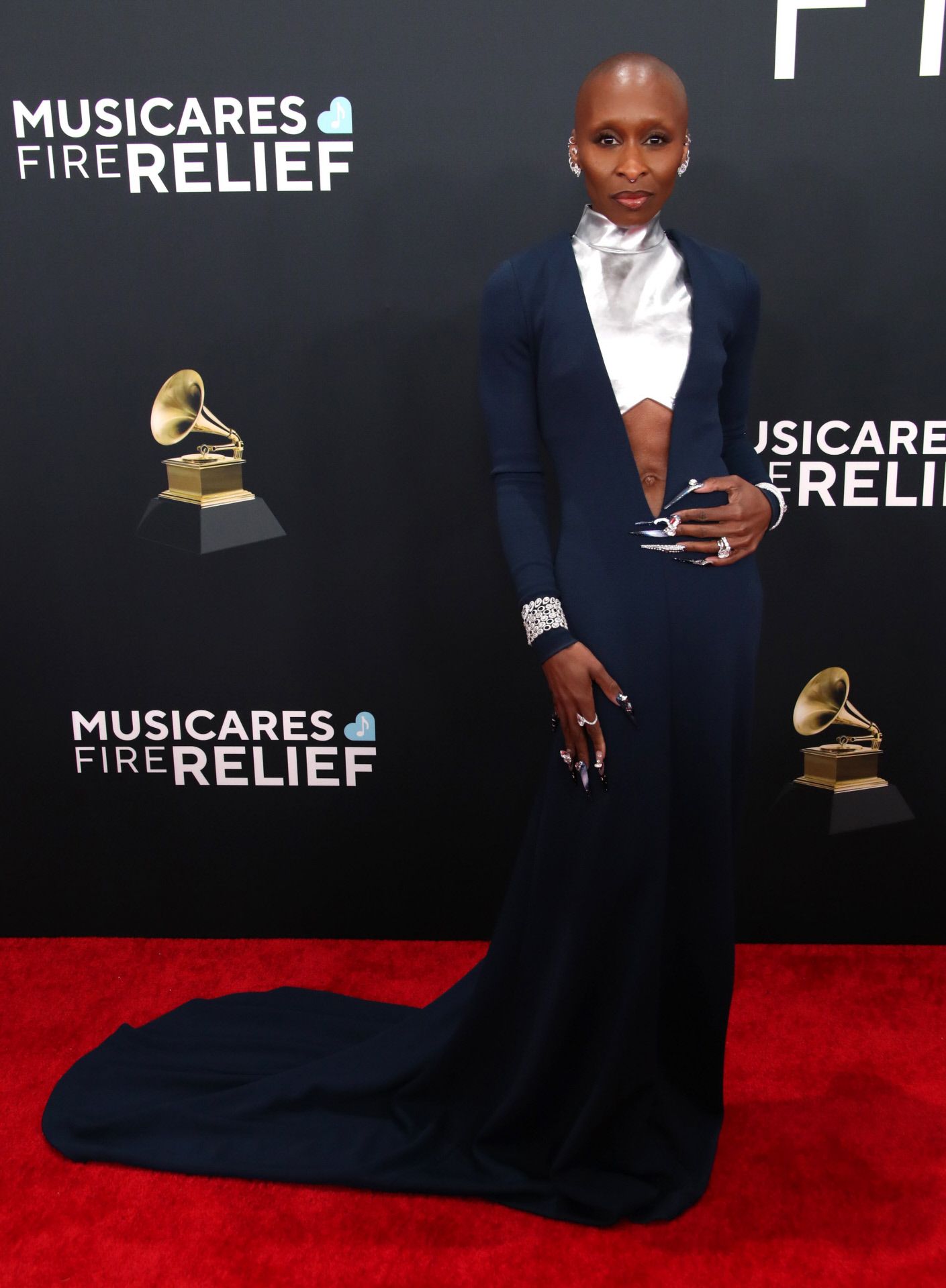 La actriz Cynthia Erivo llevó un vestido azul marino con la zona del escote en plateado de Louis Vuitton. Además, lució joyas de la marca francesa Messika: pendientes Firebird, combinados con las pulseras Hypnotic Scale, Diamond Frequencies y Divine Enigma. Completó su sofisticado conjunto con los anillos Concorde y Cushion.