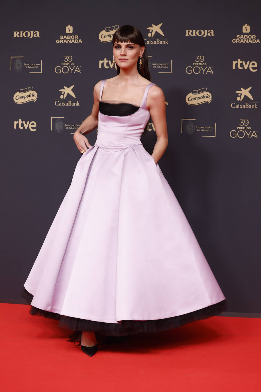 Amaia Salamancara con un vestido de Carolina Herrera New York, con falda de gran volumen, tirante fino y encaje negro asomando por el bajo y el escote. Lo combinó con calzado de Hispanitas y joyas de Carrera y Carrera. Además, la actriz estrenó look: una melena más oscura con flequillo corto. 