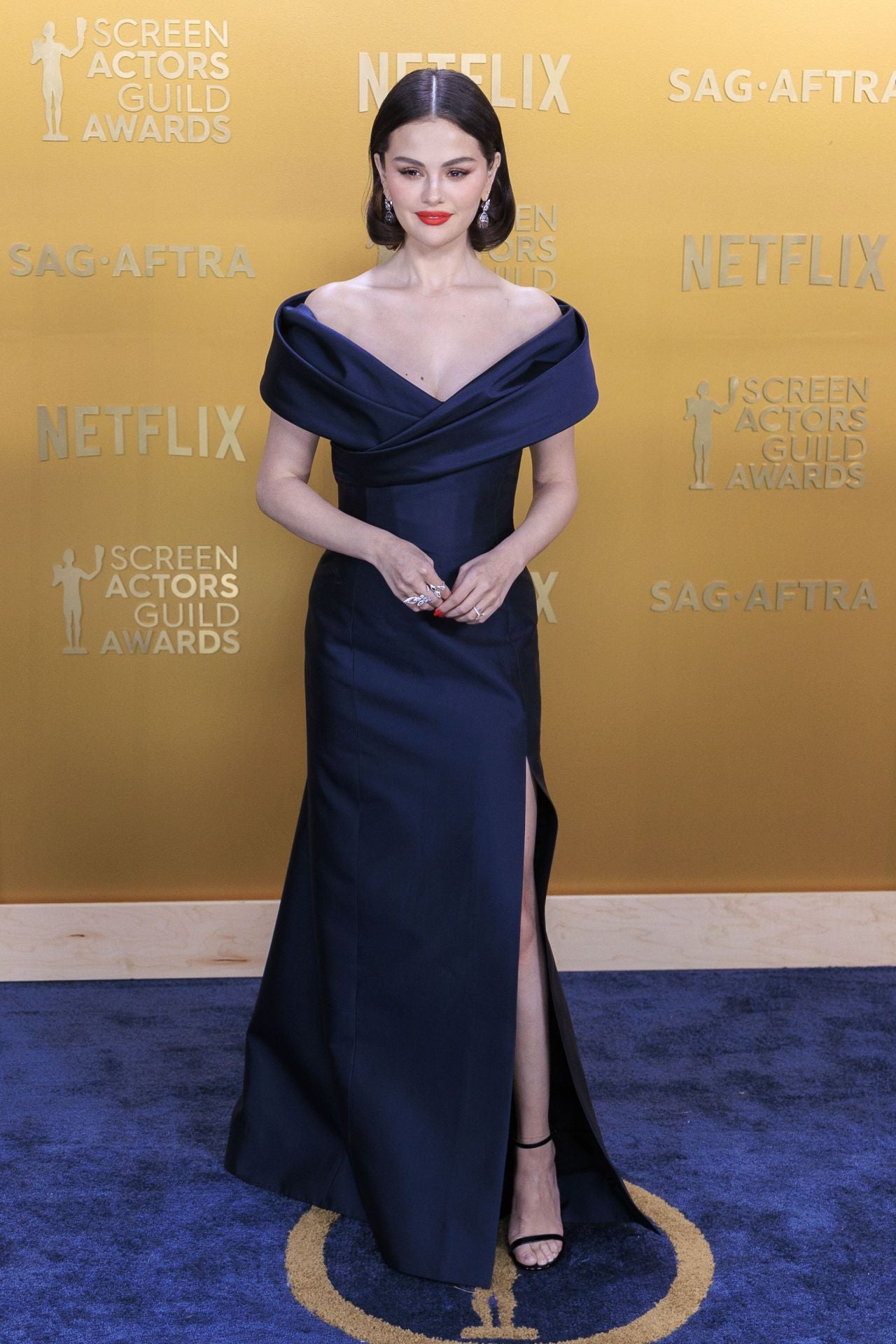 La acrtiz Selena Gómez con vestido de escote 'bardot' en un elegante azul marino de Celine hecho a la medida.