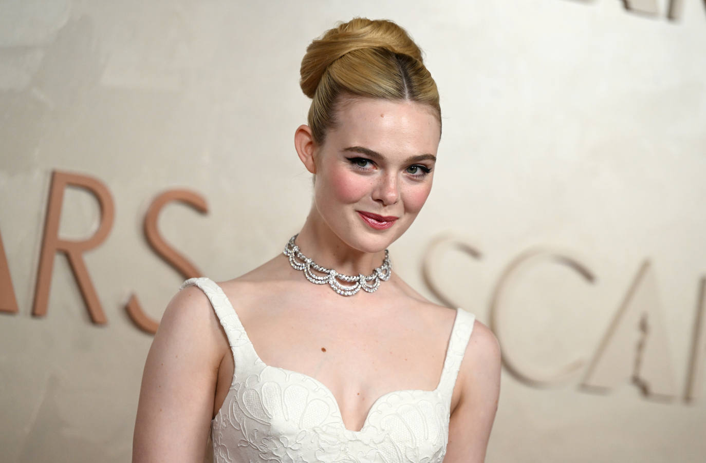 Elle Fanning optó por el combo ganador en estos premios: moño estructurado y maquillaje con eyeliner negro. Además, la actriz completó su 'beauty look' con labios rojos. 