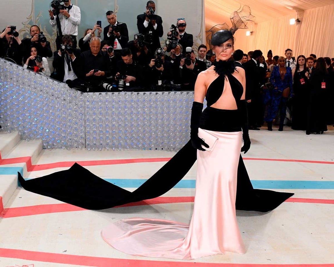 En 2023, Jennifer Lopez arrasó en la alfombra roja con un diseño de Ralph Lauren compuesto por un top 'cut out' con escote 'halter' decorado con una camelia en honor a Karl Lagerfeld y espalda descubierta con un gran lazo en cola y una falda larga satinada en color rosa también con cola. Además, remató el look con un tocado en el pelo.