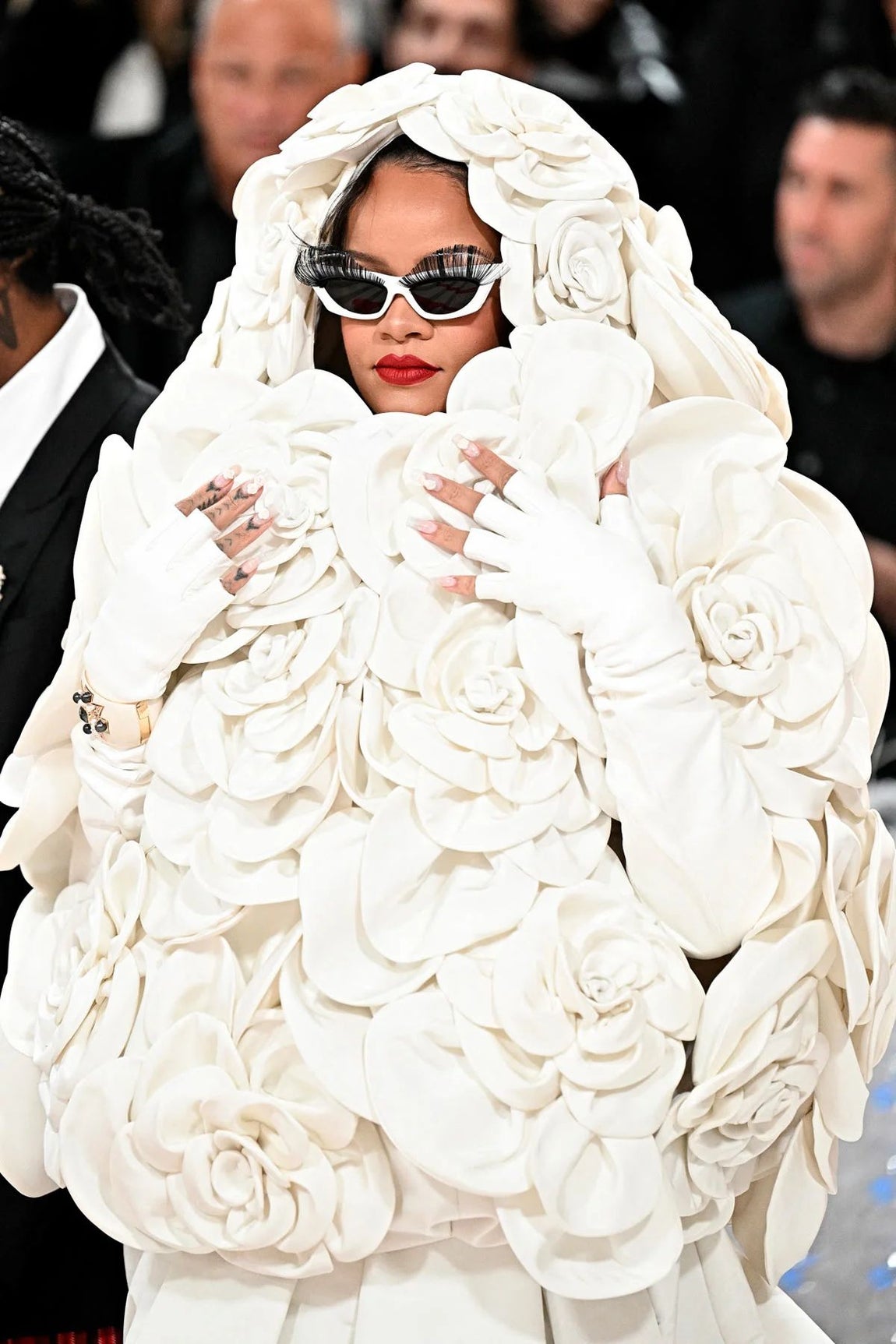 En 2023, Rihanna fue la última en llegar a la alfombra roja con un atuendo que no pasó desapercibido. Escogió un vestido blanco de Valentino de Alta Costura adornado con 30 enormes camelias en el mismo tono que cubrían su torso, brazos y cabeza y una gran cola. Con labios rojos, llevó unas gafas de sol a juego con pestañas incluidas.