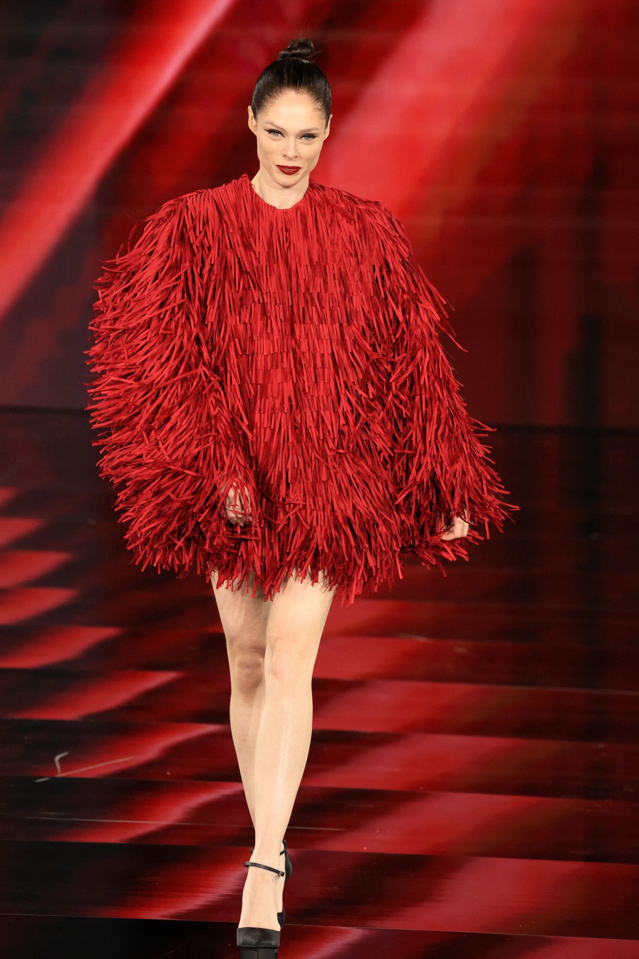 Coco Rocha lució un minivestido con flecos que combinó con moño alto y labios rojos. 