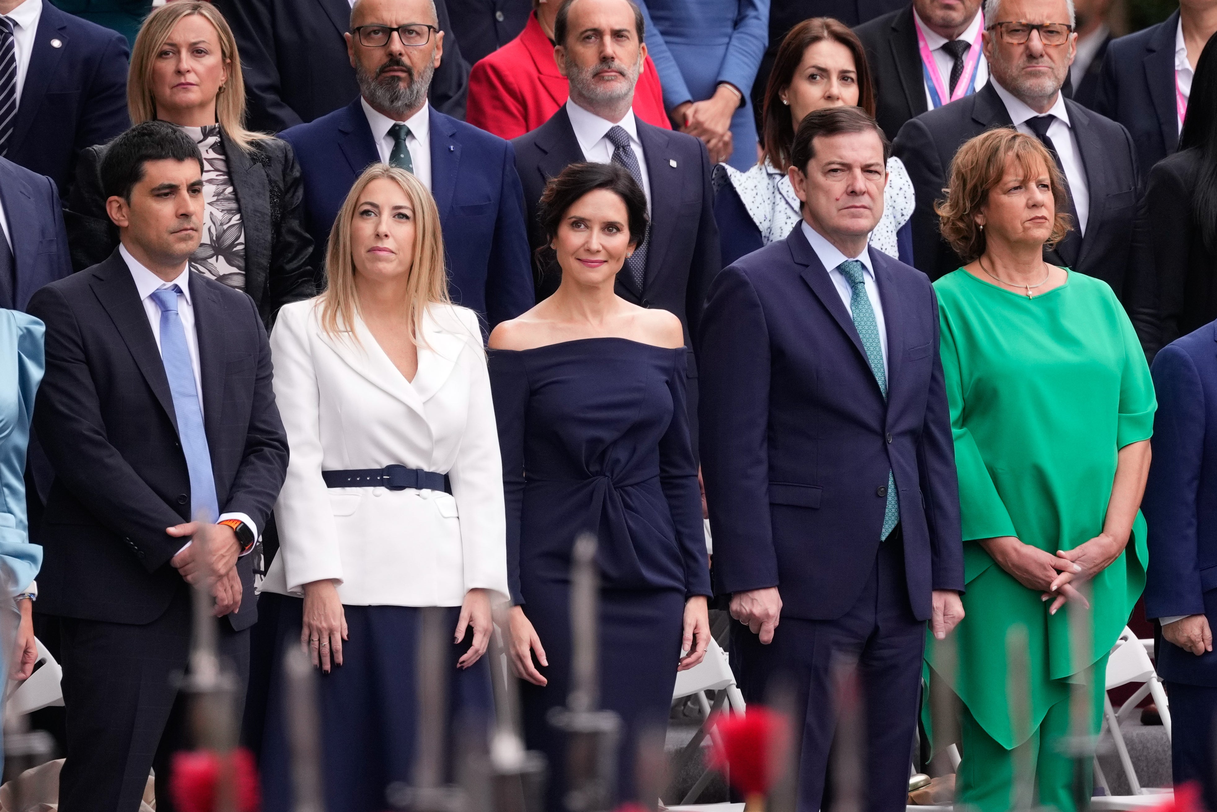 María Guardiola se ha decantado por un conjunto de falda azul marino con vuelo combinada con blazer blanca cruzada con cinturón al tono con la falda; mientras que Isabel Díaz Ayuso ha vuelto a apostar por un diseño de Victoria Colección en color azul y drapeado en el cuerpo. 
