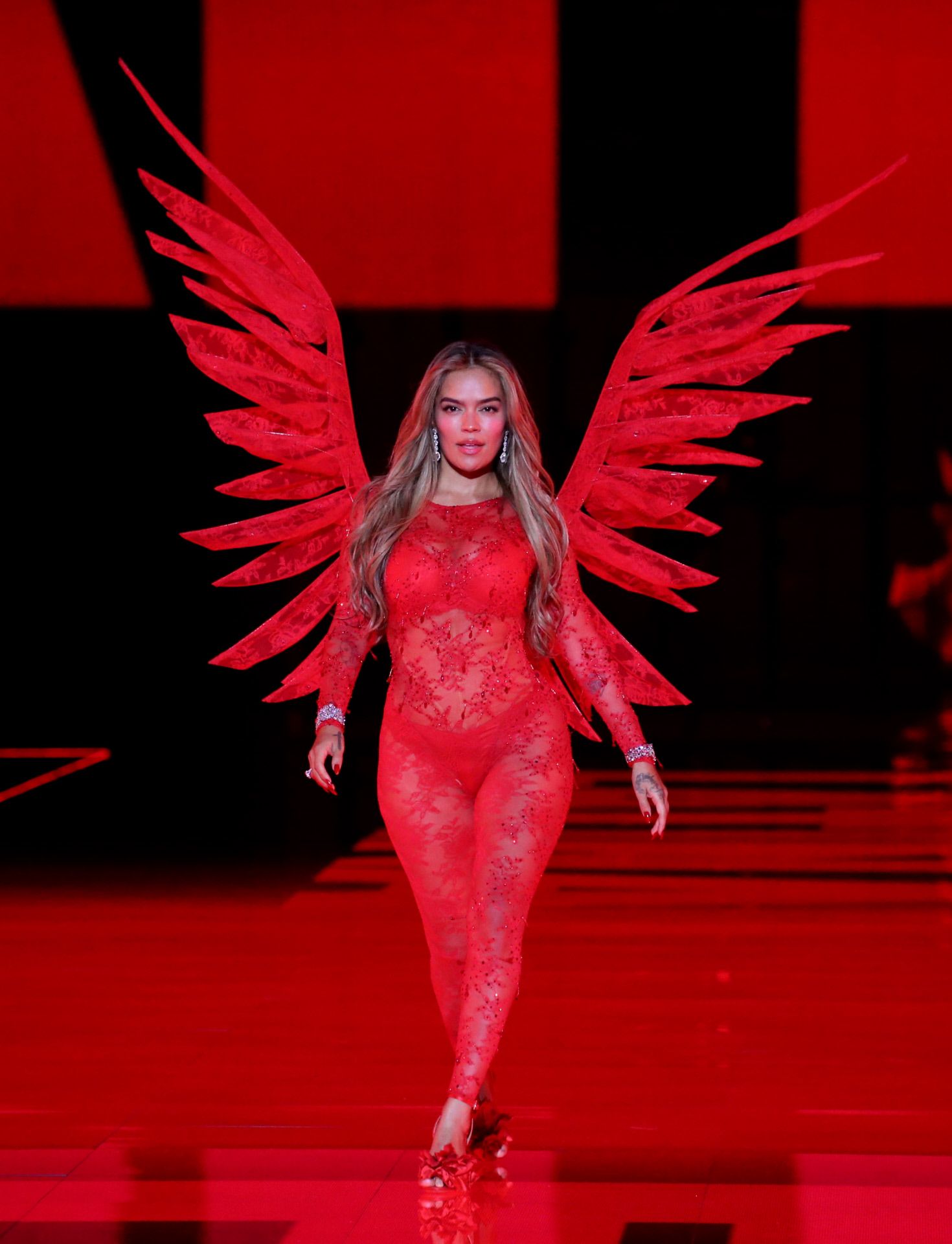 Karol G se enfundó en un conjunto rojo de encaje  y desfiló con las míticas alas de los ángeles de Victoria's Secret. 