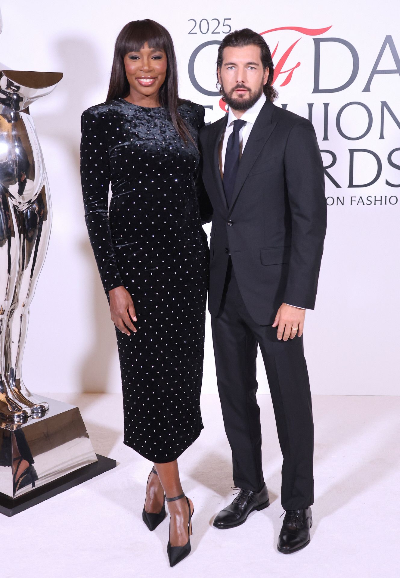 Venus Williams, lució un vestido midi de teriocpelo con apliques metalizados, y posó con su marido, Andrea Preti.