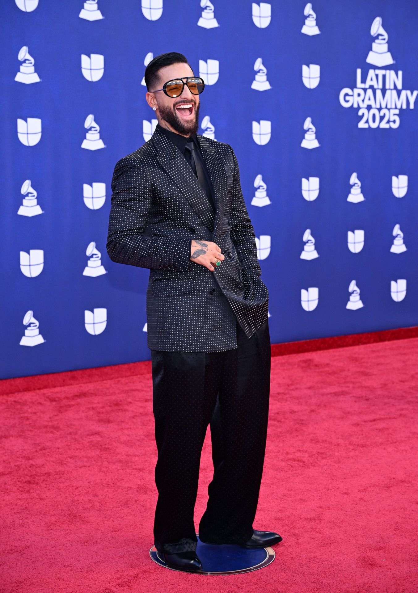 Maluma lució un dos piezas con pantalón ancho y blazer con lunares blancos. No faltaron las joyas: pendientes de diamantes y anillo con esmeralda. 