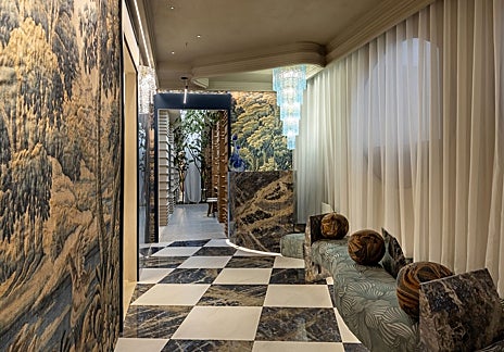 Imagen secundaria 1 - Baño de Kaldewei por IVL Isabel López Vilalta, con sus piedras en primer plano y la gama cromática ganadora, en tonos tierra; el lobby de Sandra Antón, con sofá en curva, pared entelada y luminaria decorativa, y el espacio Mapei por Cano y Escario Arquitectura, con más curvas y otro de los techos protagonistas de la feria.