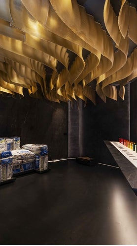 Imagen secundaria 2 - Baño de Kaldewei por IVL Isabel López Vilalta, con sus piedras en primer plano y la gama cromática ganadora, en tonos tierra; el lobby de Sandra Antón, con sofá en curva, pared entelada y luminaria decorativa, y el espacio Mapei por Cano y Escario Arquitectura, con más curvas y otro de los techos protagonistas de la feria.