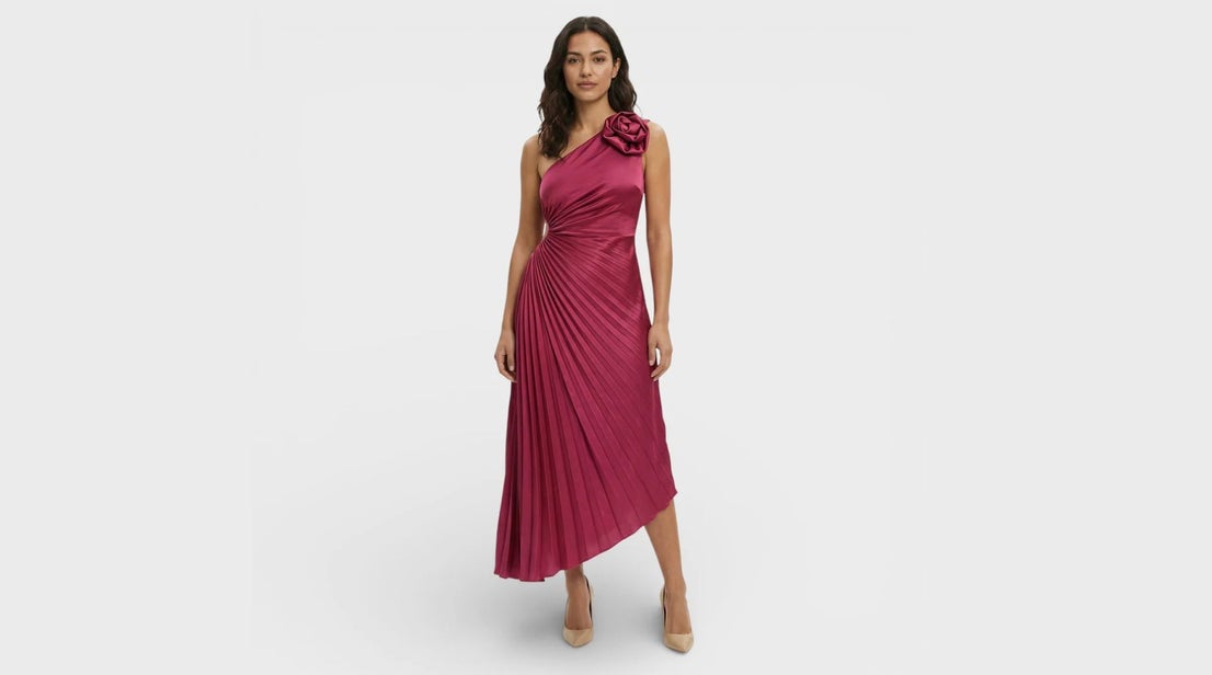 Vestido de escote asimétrico y falda plisada con cintura ceñida y detalle de flor en el hombro. Precio: 44,95€. WEB: https://aitana-sevilla.es/