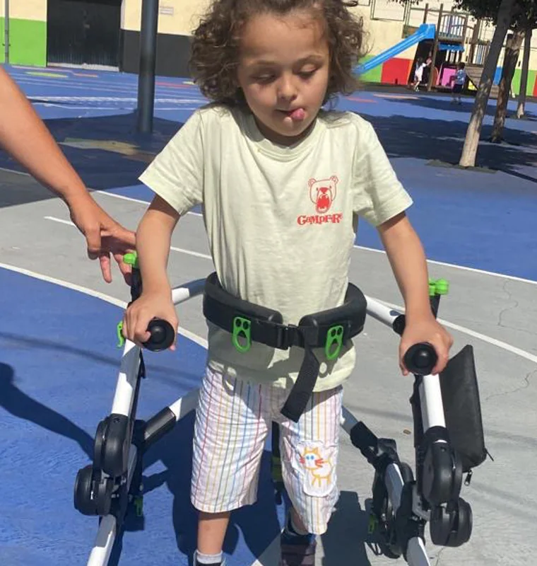 Mateo has motor difficulties and requires a walker to facilitate his mobility.