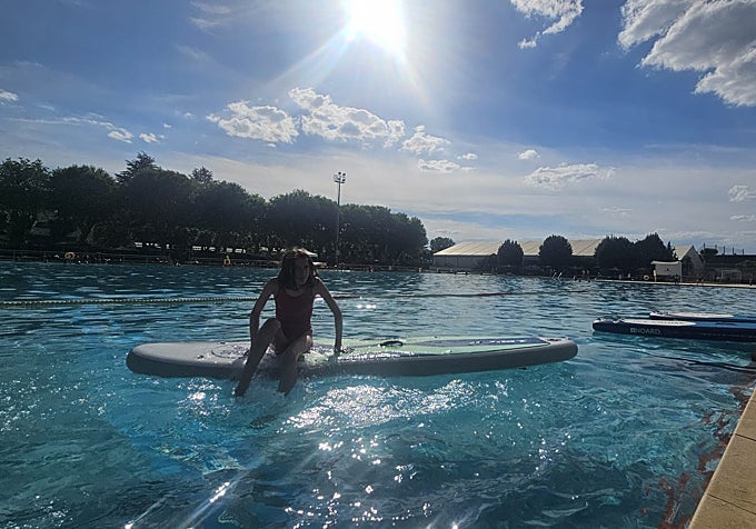 Una niña está tomando clases de paddle surf en la federación.