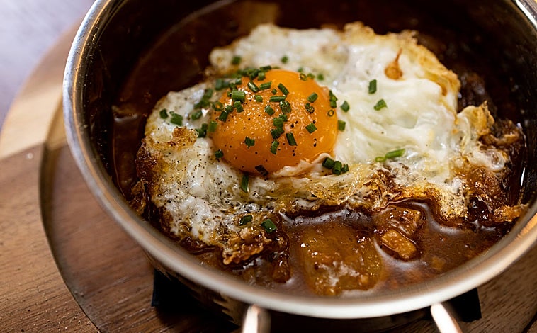 Imagen principal - Arriba, guiso de callos con huevo frito en La Barra de la Reme. Abajo, su croqueta de pote gallego y las 'bravas muy bravas' que sirve este nuevo espacio del barrio de Salamanca