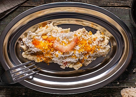 Imagen secundaria 1 - Sobre estas líneas, arriba, las patatas bravas. Abajo, a la izquierda, la ensaladilla 'golpeá' de gambón. A la derecha, Daniel Montes y Ana Romero, en la puerta de La Taberna del Lobo de Malasaña