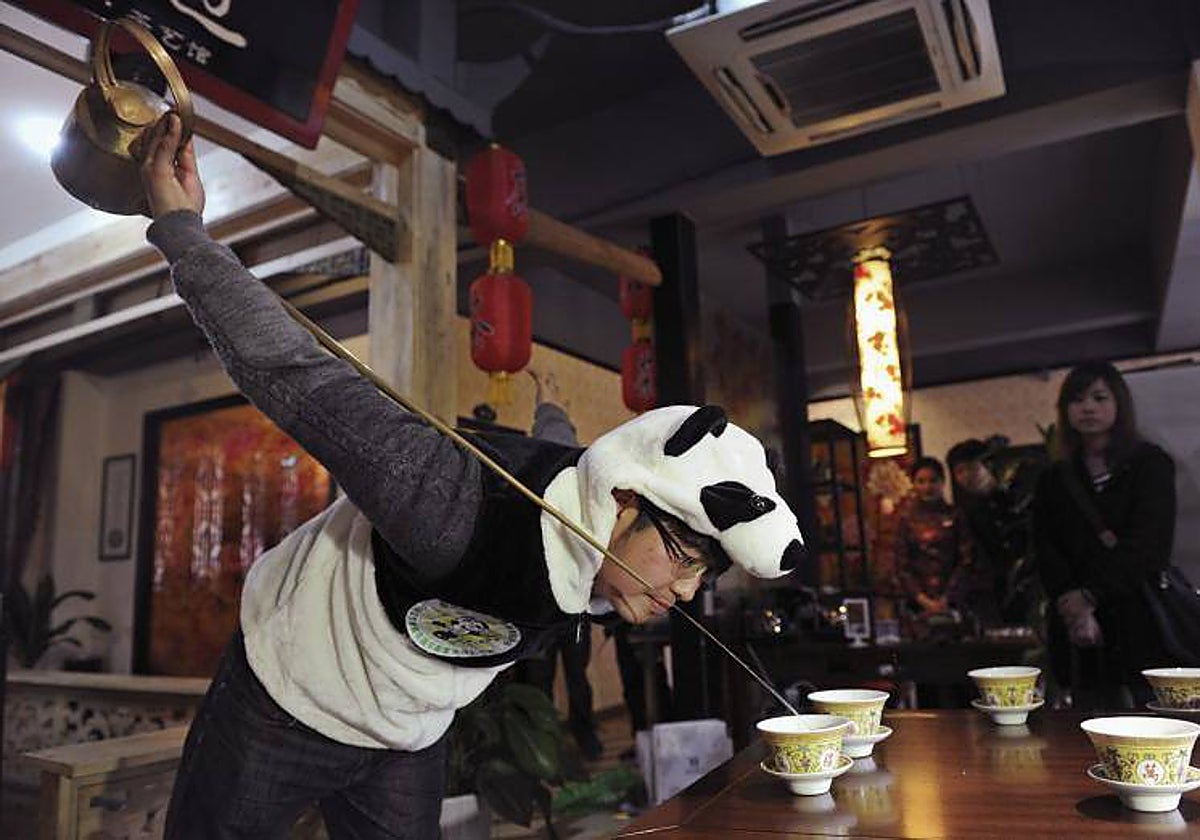 An Yanshi sirve una taza de su té, elaborado con excrementos de osos panda