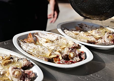 Imagen secundaria 1 - Sobre estas líneas, arriba, Mikel Manterola. Abajo, a la izquierda, besugos al estilo Orio recién salidos de la parrilla y recibiendo el refrito de ajos, guindilla y vinagre. A la derecha, los pimientos asados del Bodegón Joxe Mari