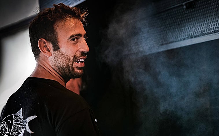 Imagen principal - Sobre estas líneas, arriba, Mikel Manterola. Abajo, a la izquierda, besugos al estilo Orio recién salidos de la parrilla y recibiendo el refrito de ajos, guindilla y vinagre. A la derecha, los pimientos asados del Bodegón Joxe Mari