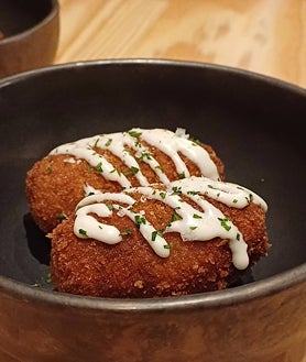 Imagen secundaria 2 - Sobre estas líneas, arriba, una de las pizzas fritas de Morso, perfectamente sellada y sin exceso de grasa. Abajo, las albóndigas de queso y huevo con salsa de tomate y, a la derecha, las croquetas de arroz