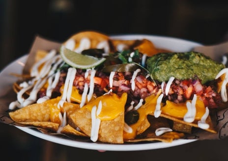 Imagen secundaria 1 - Sobre estas líneas, la hamburguesa 'Heidi Love' servida a modo de raclette. Abajo, los nachos de La Carnaza y Miguel Crespo, fundador del proyecto