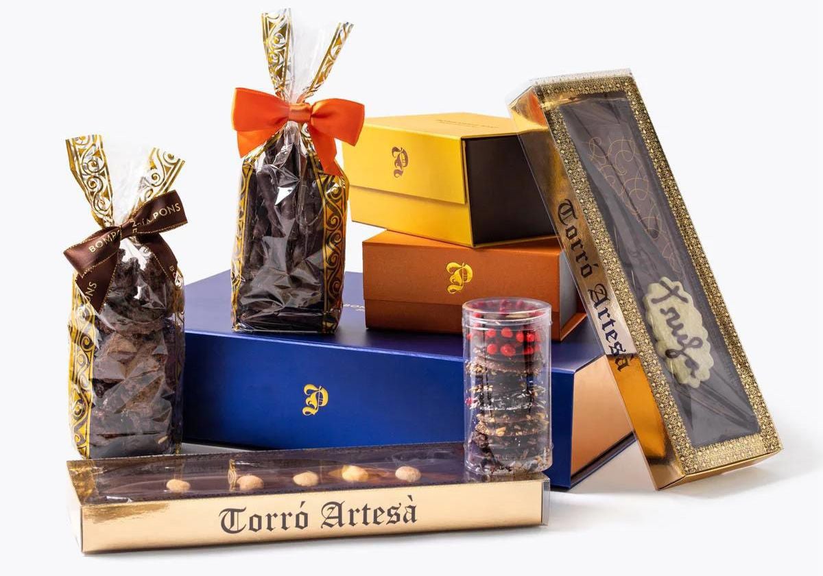 Lote de Bombonería Pons. Incluye 2 turrones ,un cofre de bombón surtido, un cofre de almendras al cacao, una bolsa de  ñaps, una bolsa de barritas de naranja y un bote de chips de chocolate. 75 euros.