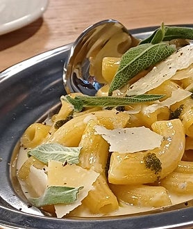 Imagen secundaria 2 - Sobre estas líneas uno de los 'pizzaioli' del nuevo Parking Pizza de Madrid, en el paseo de la Castellana 89. Abajo, a la izquierda, una ración de 'bresaola' con virutas de apio, pimienta y ralladura de lima. A la derecha, 'rigatoni' con gorgonzola, queso 'taleggio' y salvia