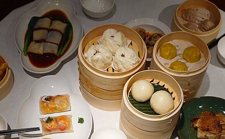 Imagen principal - Sobre estas líneas algunas de las elaboraciones que llegan a la mesa en el carrito de vapor de Lelong Asian Club, con baos, xiao long baos, hakaos, patas de pollo o arroz en hojas de loto, entre otros
