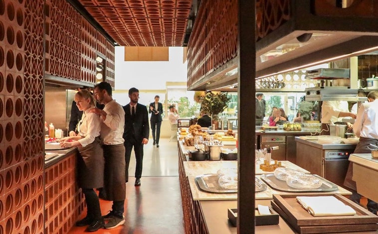 Imagen principal - Sobre estas líneas, la cocina vista de Disfrutar. Abajo, varios de los pases que componen sus menús degustación