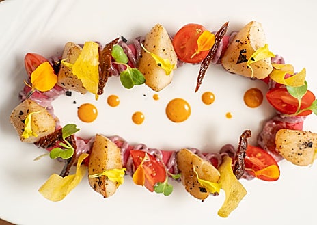 Imagen secundaria 1 - Sobre estas líneas, arriba, la sala del restaurante Es Arraïtzes. Abajo, a la izquierda, uno de los platos que sirve su chef César Mory (derecha)