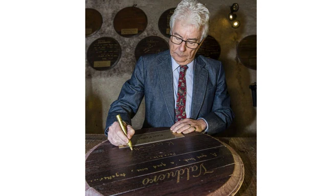 Ken Follet firmando una barrica en 'La Tenada de Valduero'