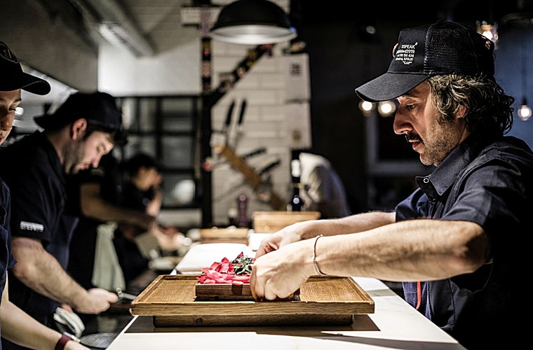 Diego Guerrero durante el pase de uno de los platos de su menú, en la barra que separa la cocina de DSTAgE de la sala