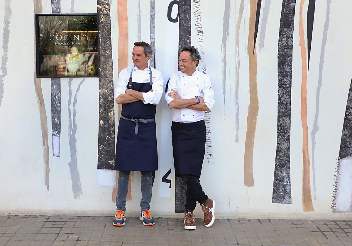 Javier y Sergio Torres en la fachada de Cocina Hermanos Torres, su tres estrellas Michelin de Barcelona
