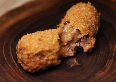 Imagen secundaria 1 - Sobre estas líneas, arriba, el steak tartar tibio sobre medio hueso de caña con su tuétano y patatas soufflé. Debajo, a la izquierda, la croqueta de pato, todo un icono en Barcelona. Al lado las colmenillas rellenas de foie de Toni Romero