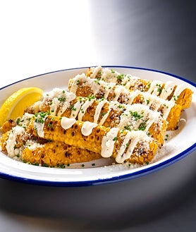 Imagen secundaria 2 - El restaurante Piri Piri, en Las Tablas, Madrid; sus propietarios y su plato de mazorcas de maíz asadas