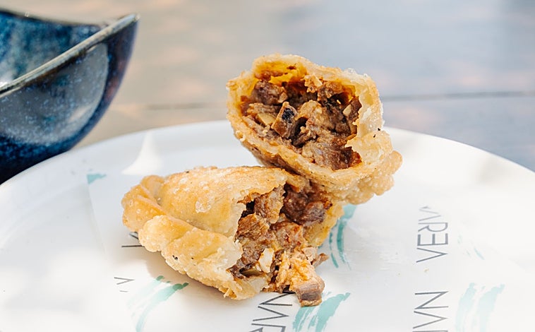 Imagen principal - Algunos de sus platos estrella como la empanada de asado frita (arriba), sorrentinos de setas y trufa con gamba roja (en el medio) y tataki de pez (última)