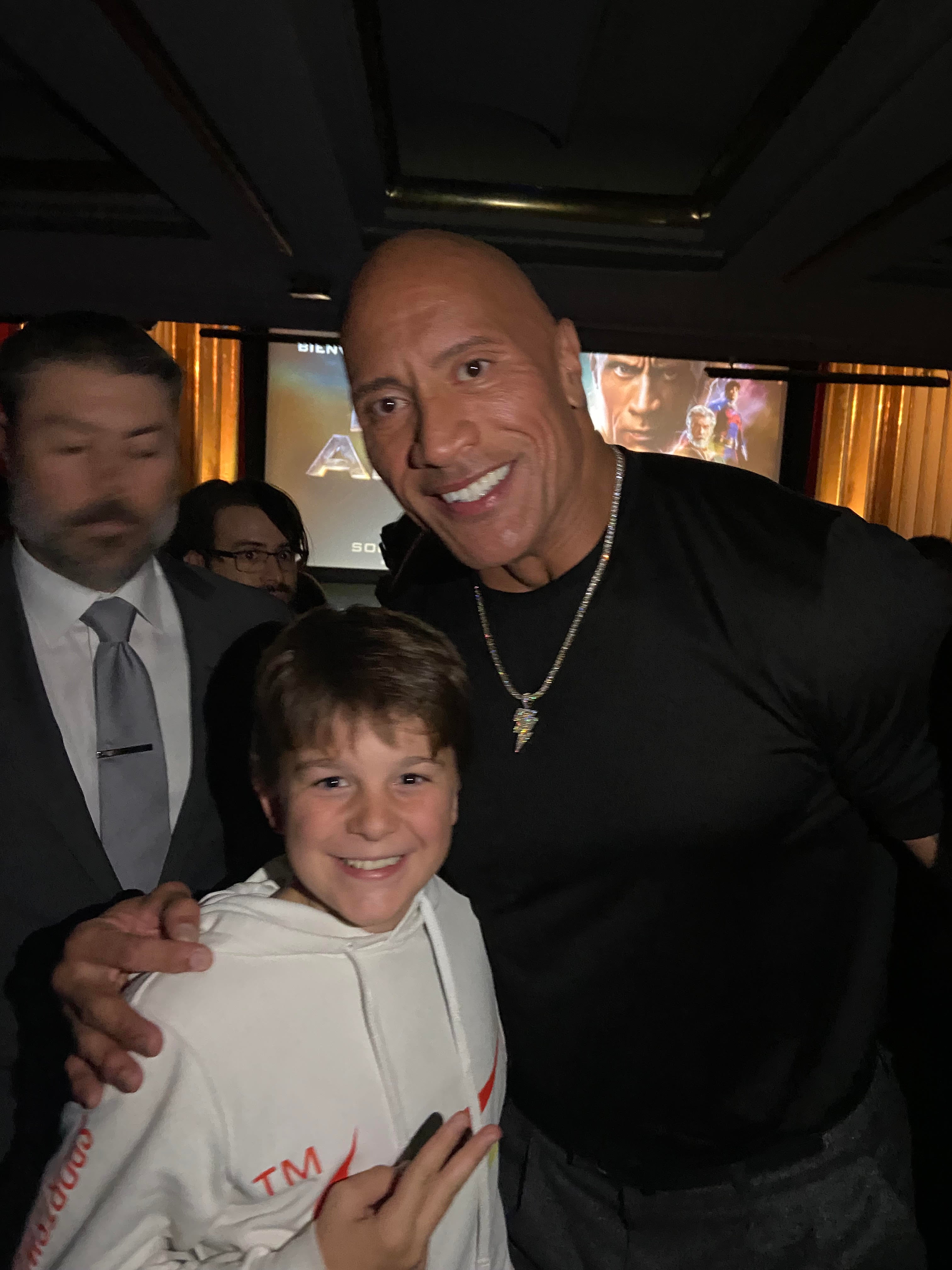 Dwayne Johnson con uno de los muchos fans que le esperaban en la Gran Vía, durante la premier de la película "Black Adam"