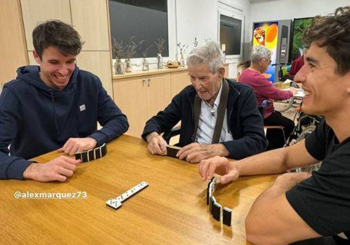 Alex y Marc, con su abuelo en el centro durante la partida de dominó