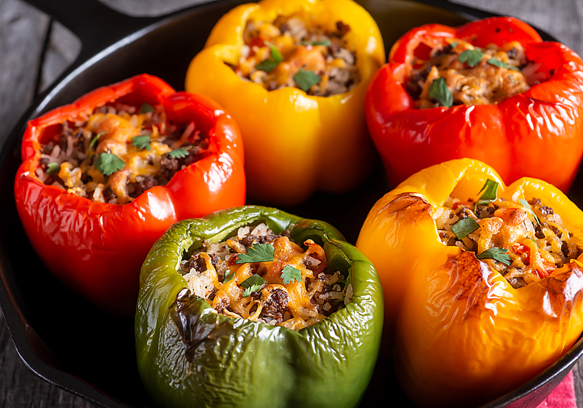 Pimientos rellenos de carne y verduras y un vasito de arroz brillante