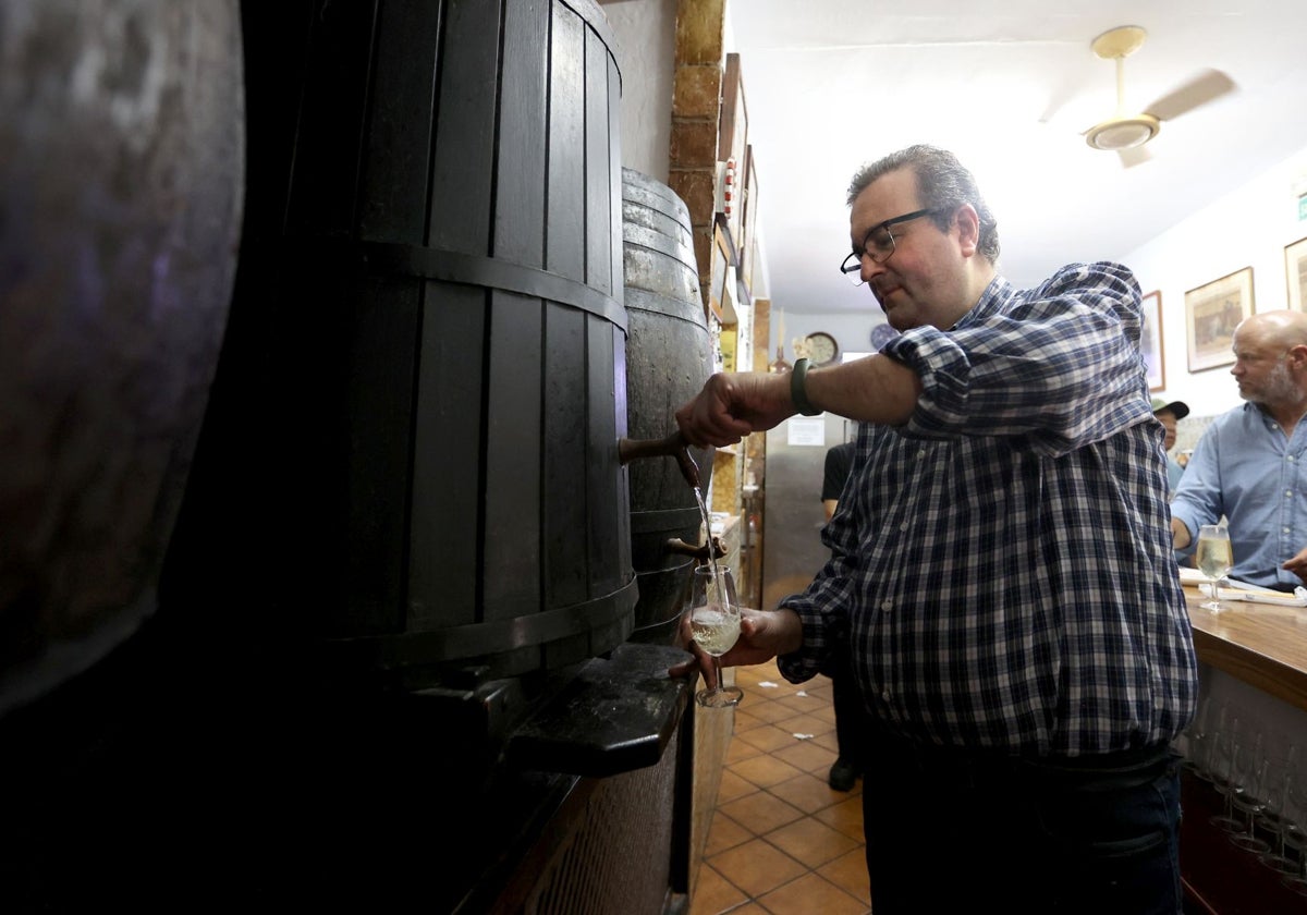 Rafael Guzmán llena un medio de vino, en la Bodega Guzmán