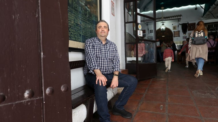 Rafael Guzmán, sentado a la entrada, junto a uno de los centenarios carteles expuestos