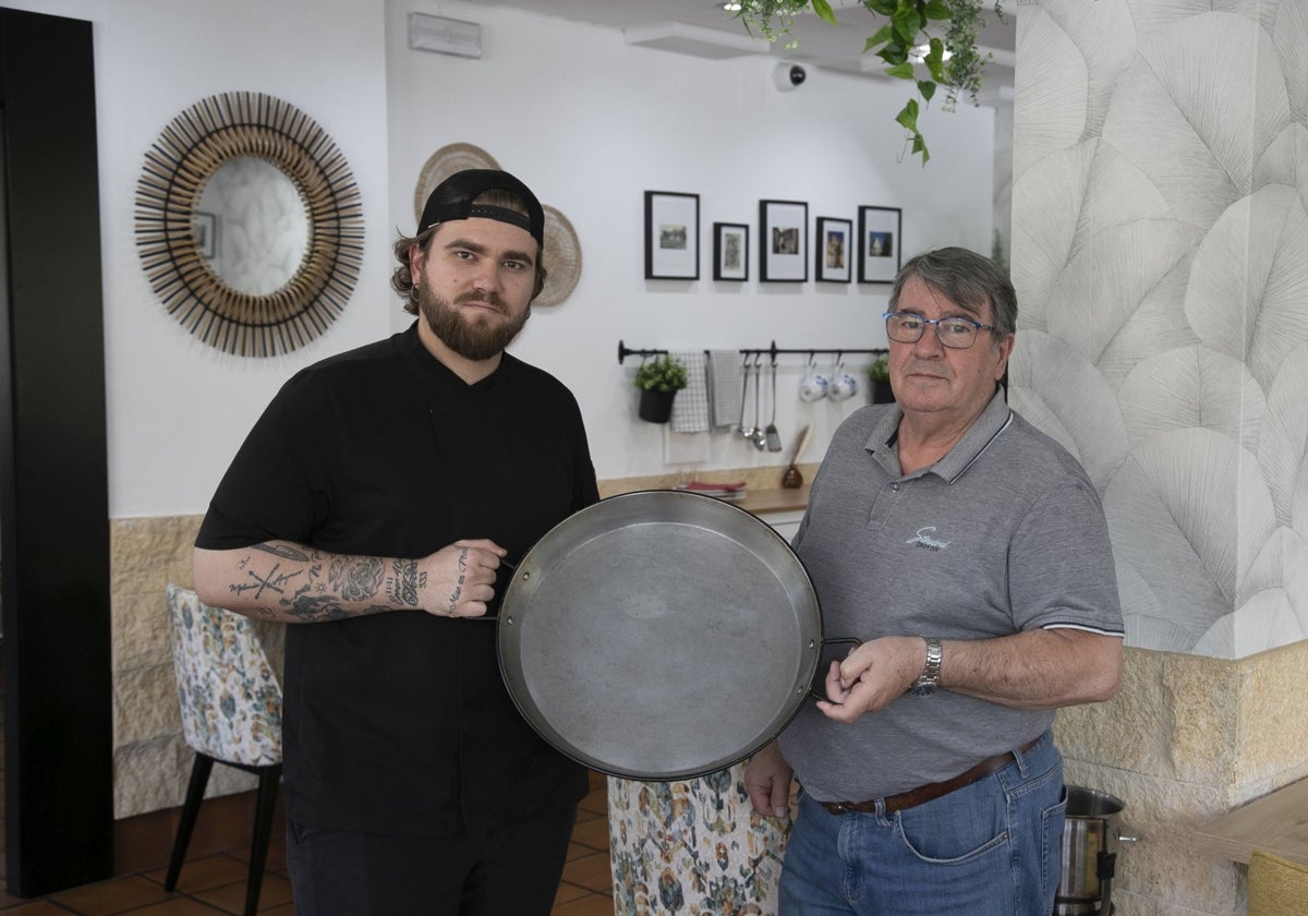 José Miguel Sanchís y su padre, Pepe Sanchís, con una paellera en el interior del restaurante arrocería