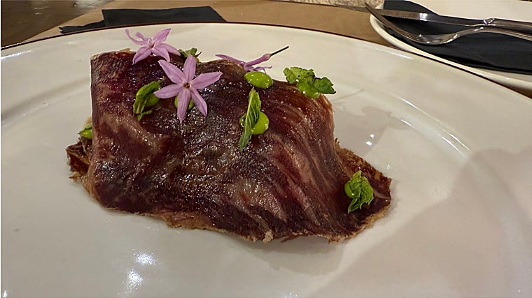 Guiso de lagartito ibérico con tomate cubierta con cecina de Wagyu y brotes de hierbabuena