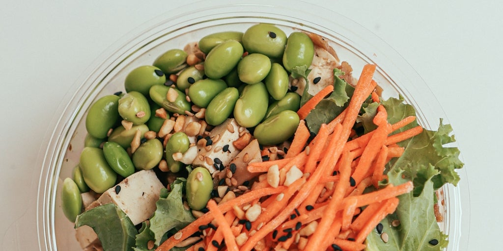 Ensalada de hojas verdes, vasito de granos de avena Brillante, edamame, remolacha, zanahoria y maíz