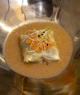 Imagen secundaria 2 - En la imagen superior, un camarero atiende una mesa durante el brunch. Debajo a la izquierda, diversas tapas y el plato de atún con salsa de rabo de toro. A la derecha, la tapa de El Horno de Mel para el Califato Gourmet 2025, ravioli de pluma ibñerica de bellota 